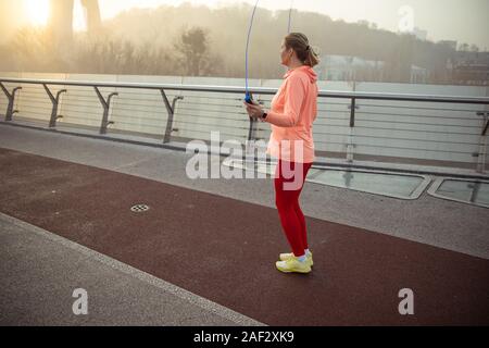 Sportliche junge Frau über Springseil springen Stockfoto