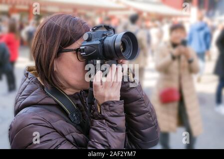 Frau touristische Fotos mit einer Digitalkamera im Stadtzentrum an einem sonnigen Tag Stockfoto