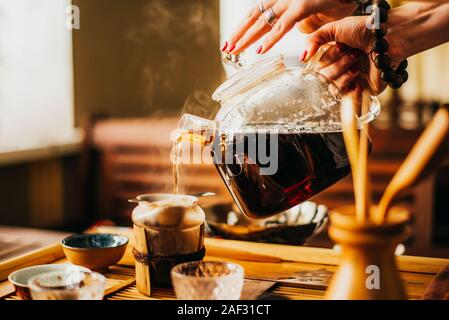 Mädchen gießt frisch gebrühten Kaffee im Kaffee Stockfoto