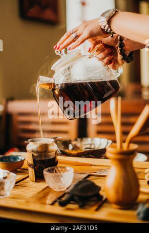 Mädchen gießt frisch gebrühten Kaffee im Kaffee Stockfoto