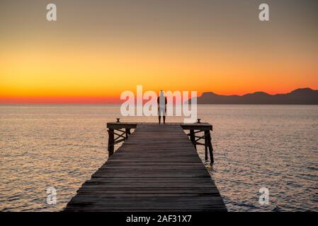 Allein Frauen entspannen Sie auf Holz- Dock in der ruhigen See, Silhouette Stockfoto
