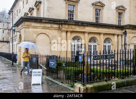 Badewanne, Somerset, UK. 12 Dez, 2019. Ein Mann gegen die starken Regen und gehen in die 2019 Bundestagswahl zur Abstimmung wird dargestellt, wie er ein Wahllokal, die in der Assembly Rooms, einem Gebäude aus dem 18. Jahrhundert im Zentrum von Bath eingestellt wurde. Credit: Lynchpics/Alamy leben Nachrichten Stockfoto