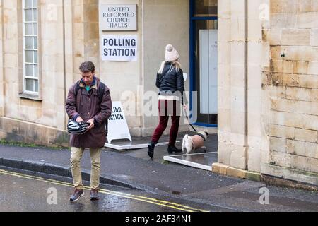 Badewanne, Somerset, UK. 12 Dez, 2019. Die Wähler in die 2019 Bundestagswahl zur Abstimmung abgebildet trotzen dem Regen und Betreten und Verlassen eines Wahllokals, die als in einer Kirche Halle im Zentrum von Bath. Credit: Lynchpics/Alamy leben Nachrichten Stockfoto