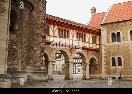 Historische Altstadt von Braunschweig, Niedersachsen in Deutschland. Schlossplatz durch die Torbögen der Burg und Braunschweiger Löwe Statue gesehen. Stockfoto