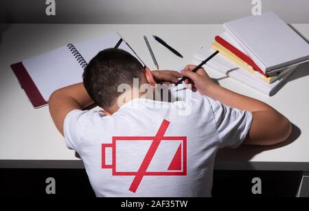 Gelangweilt und müde Junge Hausaufgaben auf weißem Schreibtisch in seinem Zimmer. Schüler Probleme Konzept. ISo Stockfoto