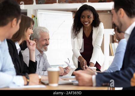 Diverse Geschäftsleute versammelte für Verhandlungen, die von afrikanischen Geschäftsfrau führen. Stockfoto