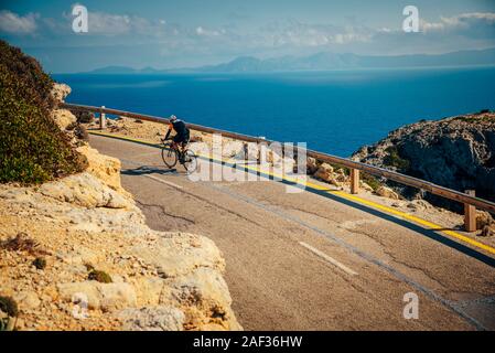 Athleten auf der Straße mit dem Fahrrad durch das Meer Sport in der wunderschönen Natur. Stockfoto