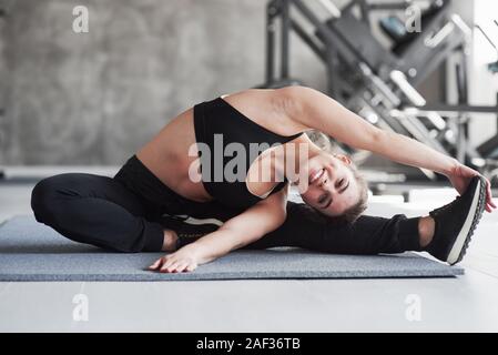 Kommen und Yoga mit mir. Foto von gorgeous blonde Frau in der Turnhalle am Wochenende Zeit Stockfoto