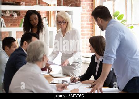 Team und gealterte Boss stellen Schreibarbeit Analyse Finanzbericht Stockfoto