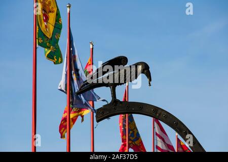 Heraldischen Symbol für ein Rabe mit einem siegelring. von König Matthias auf die Krähe Gate der Budaer Burg mit Wappen Flaggen hinter. Winter in Budapest, Hunga Stockfoto