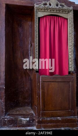 Alte konfessionelle, in der Italienischen Kirche mit roten Vorhang Stockfoto