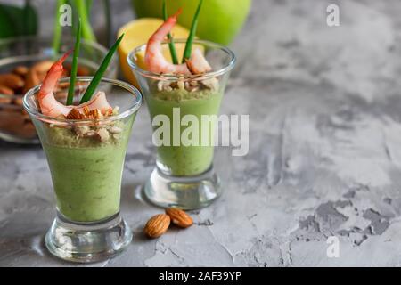 Avocado- und grüner Apfel Mousse mit Garnelen und Mandeln. Teil Vorspeise für ein Buffet oder Bankett in ein Glas. Stockfoto