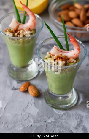 Avocado- und grüner Apfel Mousse mit Garnelen und Mandeln. Teil Vorspeise für ein Buffet oder Bankett in ein Glas. Stockfoto