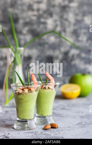 Avocado- und grüner Apfel Mousse mit Garnelen und Mandeln. Teil Vorspeise für ein Buffet oder Bankett in ein Glas. Stockfoto