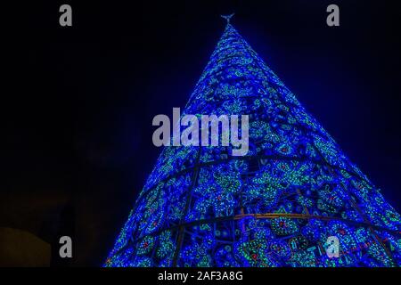 Eine große, blau, konische Weihnachten Baum in Puerta del Sol im Zentrum von Madrid, Spanien, nachts beleuchtet. Stockfoto