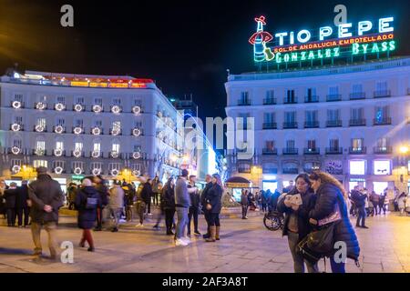 Die Puerta del Sol, im Zentrum von Madrid, Spanien in der Nacht, die Tio Pepe Leuchtreklame leuchtet über der überfüllten Stadt Zentrum öffentlichen Platz Stockfoto