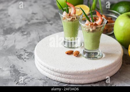 Avocado- und grüner Apfel Mousse mit Garnelen und Mandeln. Teil Vorspeise für ein Buffet oder Bankett in ein Glas. Stockfoto