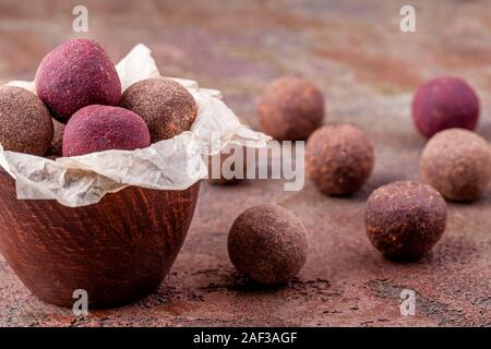 Nahaufnahme von hausgemachten Raw Vegan Cacao Energie Kugeln in der Schüssel mit Handwerk Papier Stockfoto