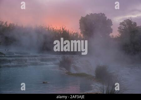 Dampf der schwefelhaltigen Wasser Anstiege über den weißen Kaskaden von den Thermalquellen bei Sonnenaufgang Stockfoto