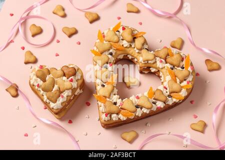 Kuchen in Herzform auf einem rosa Hintergrund für Valentinstag, Geburtstag, dem 8. März und Muttertag, Ansicht von oben Stockfoto