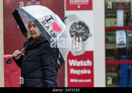 Badewanne, Somerset, UK. 12 Dez, 2019. Eine Frau Shopping in Bath, Somerset wird dargestellt, Unterschlupf unter einem Regenschirm als heftiger Regenschauer ihren Weg in ganz Großbritannien. Credit: Lynchpics/Alamy leben Nachrichten Stockfoto