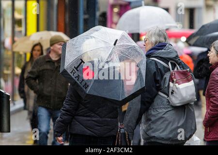 Badewanne, Somerset, UK. 12 Dez, 2019. Leute, Shopping in Bath, Somerset abgebildet Tierheim unter Sonnenschirmen als heftiger Regenschauer ihren Weg in ganz Großbritannien. Credit: Lynchpics/Alamy leben Nachrichten Stockfoto