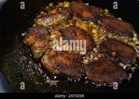 Die koteletts Pan im Feuer gebraten. Pan ist auch das Kochen Fleisch. Schwein Stücke von Fleisch sind auf ein Lagerfeuer auf einer Disc aus einer Egge gekocht. Brocken Fleisch gebraten Stockfoto