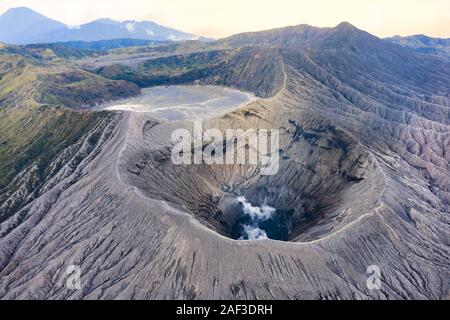 Ansicht von oben, beeindruckende Luftaufnahme des Mount Bromo mit Wolken von Gasen aus dem Krater. Mount Bromo ist ein aktiver Vulkan in East Java. Stockfoto