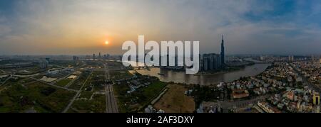 Smoggy Sonnenuntergang Panorama über Fluss Saigon in Ho Chi Minh City, Vietnam verfügt über die Skyline der Stadt. Stockfoto