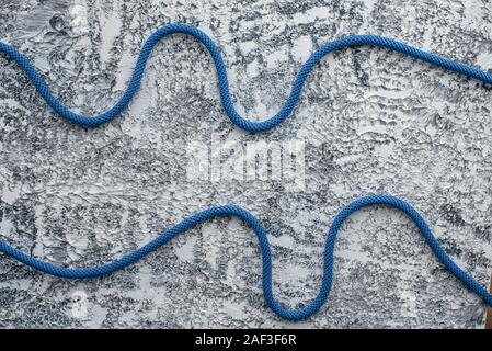 Dies ist für die Sicherheit. Isoliert Foto von klettern Knoten. Kabel liegen auf dem weißen und grauen Oberfläche Stockfoto
