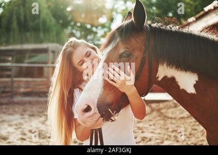 Zusammen mit bevorzugten Besitzer. Glückliche Frau mit ihrem Pferd auf der Ranch am Tag. Stockfoto