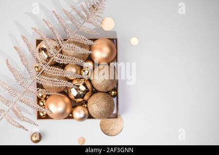 Weihnachten goldenen Dekorationen Kugeln, glänzenden dekorativen Pflanzen auf pastellfarbenen Hintergrund Stockfoto