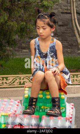 Junge Mädchen auf Getränke Fahrzeug außerhalb der Verbotenen Stadt, Peking, China sitzen Stockfoto