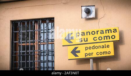 Como, Italien - 4. November 2017: gelbes Schild zeigt in die Richtung des italienischen Panoramas von Como (Panorama su Como) und Fußgängerüberweg Stockfoto