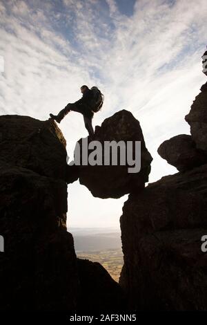 Ein Bergsteiger auf einem Unterlegkeil Stein in eine Schlucht auf Dow Crag im Lake District, UK. Stockfoto