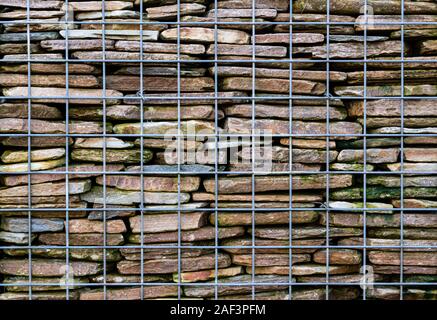 Nahaufnahme von gabionen Stützmauer, gebaut von einem Draht Käfig und Stein innen gestapelt. Stockfoto