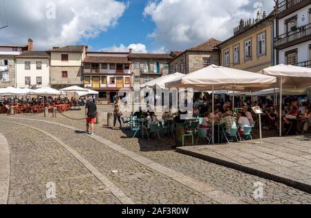 Guimaraes, Portugal - 18 August 2019: Touristen in den Cafes und Bars in der Praca de Sao Tiago in Guimaraes Stockfoto