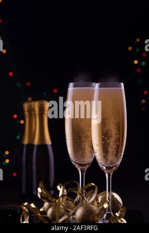 Zwei schöne Sektgläser mit glänzenden Spielzeug gefüllt. Serpentine und Leuchten. Urlaub Inhalt. Stockfoto