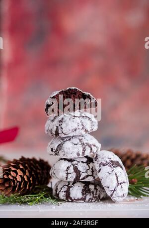 Lecker und duftenden Chocolate Chip Cookies sind mit Puderzucker zerkleinert, mit bunten Lichtern auf dem Tisch. Frohe Weihnachten Stockfoto