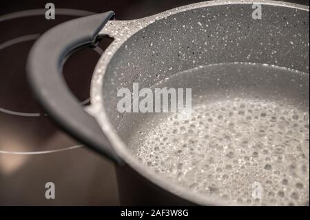 Kochendes Wasser in einem Topf auf einem Induktionsherd Stockfoto