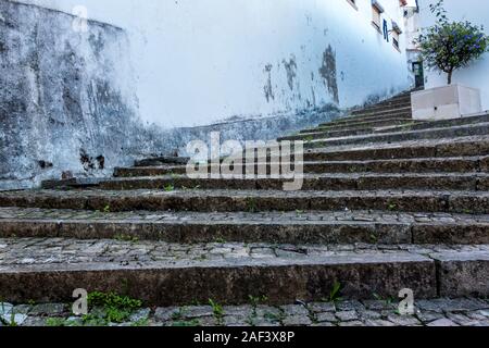 Abgenutzte Kopfsteinpflaster die Treppe nach oben und weg zu schmale Gasse zwischen den weiß getünchten Gebäuden im traditionellen Wahrzeichen der Stadt Tomar Portugal Stockfoto