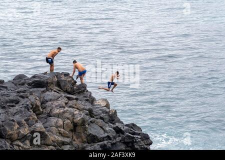 Las Palmas, Gran Canaria, Nov, 2019: Kinder in den Ozean in der Nähe von Playa de las Canteras Strand jumping, Las Palmas de Gran Canaria November 2019 Stockfoto