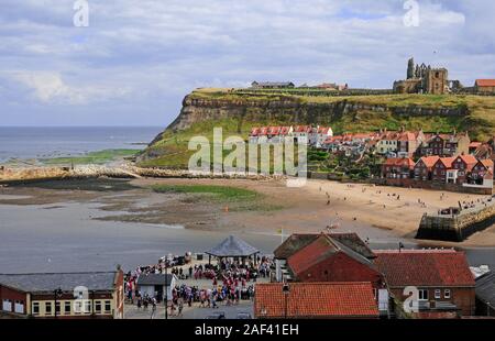 Tate Hill Beach von West Cliff, Whitby. Ebbe. Morris Dancers im Musikpavillon. Fluss Esk Mündung. Stockfoto