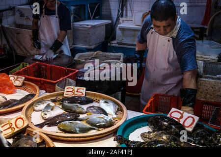 HongKong, China - November, 2019: Anbieter Vorbereitung Fische auf dem Markt in Hongkong, China Stockfoto