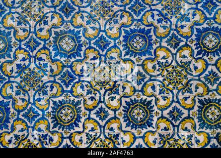 Muster der blauen und gelben alten Azulejo Kacheln an der Wand im traditionellen portugiesischen Stil Stockfoto