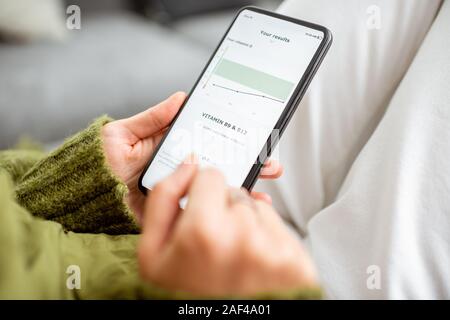 Frau online überprüft Ihre medizinische Analyse mit einem Smartphone, close-up auf einem Telefonbildschirm. Konzept der online Medizin Stockfoto
