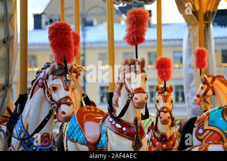 Colouful Karussell Pferde auf einem traditionellen Merry-go-round auf Weihnachtsmarkt in Helsinki, Helsinki, Finnland. Dezember 10, 2019. Stockfoto