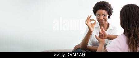 Porträt eines lächelnden Afrikanische junge Frau Lehre ihren Freund Hand Gebärdensprache Stockfoto