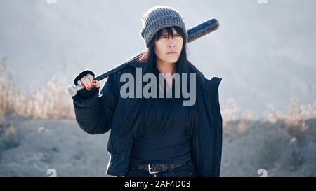 Brutale Frau von hooligan Banden geht mit einem Baseballschläger in der Einöde Stockfoto