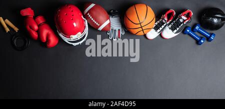 Panoramablick auf den verschiedenen Sportarten, Bälle und Ausrüstung über schwarze Oberfläche Stockfoto